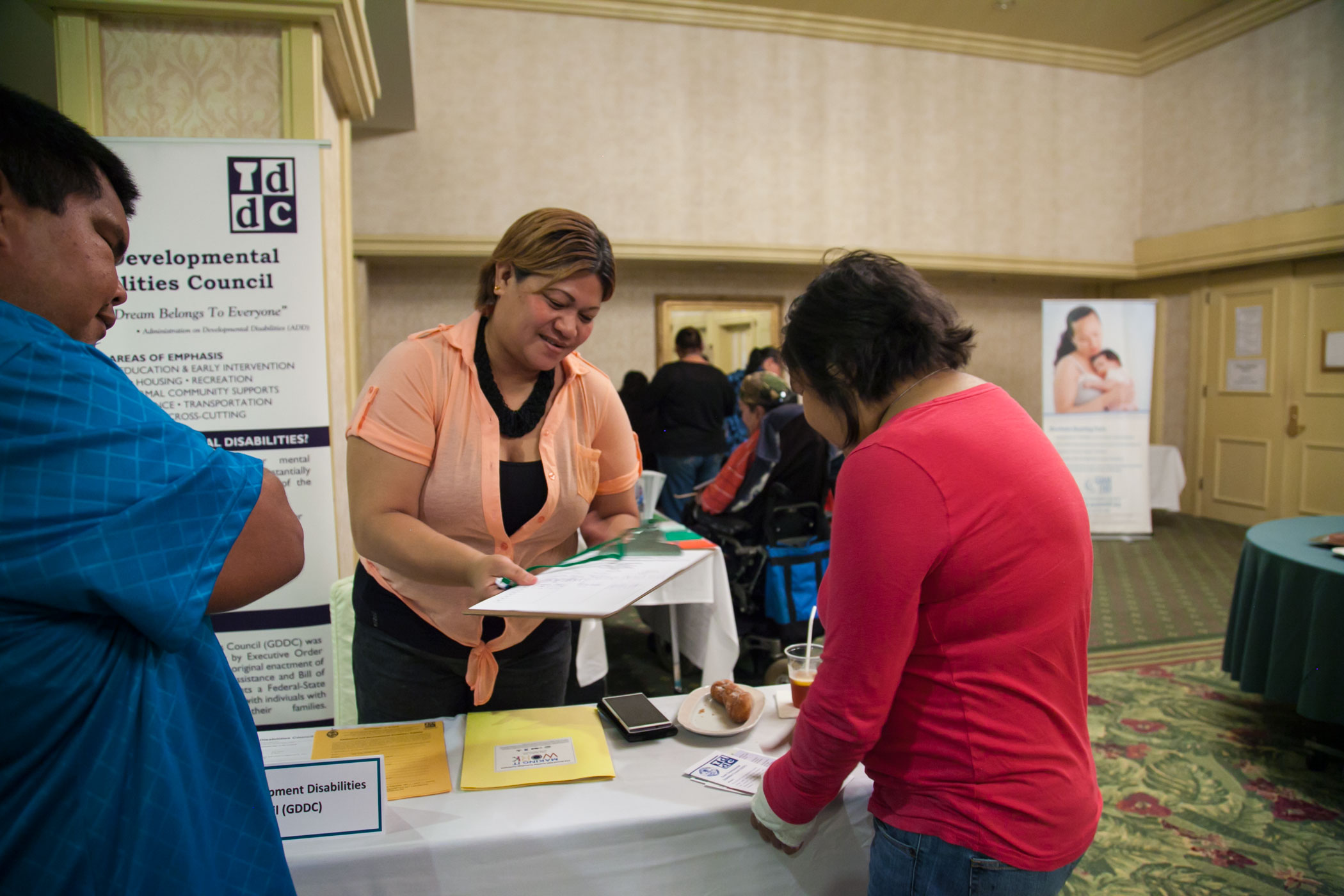 Photo of Josie Guerrero of the Guam Developmental Disabilities Council assisting a conference participant.