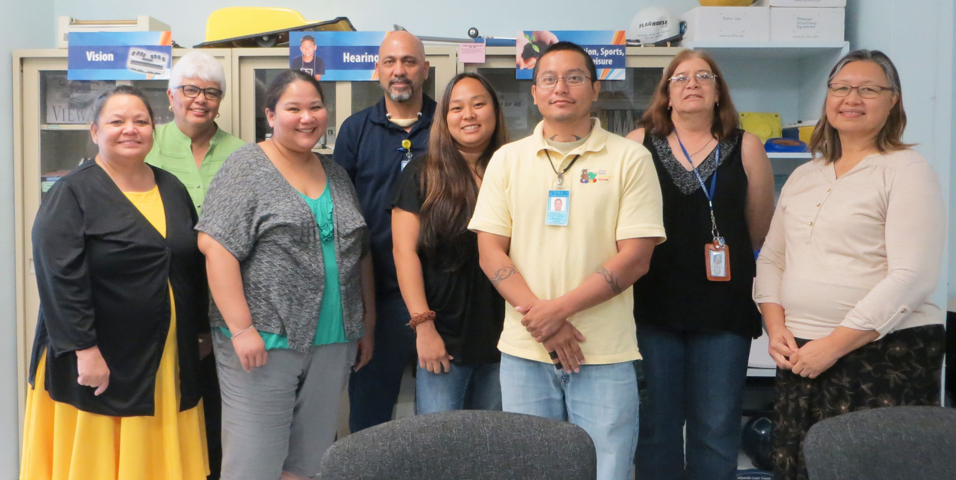 A group of individuals pose for photo at the Guam System for Assistive Technology meeting room.