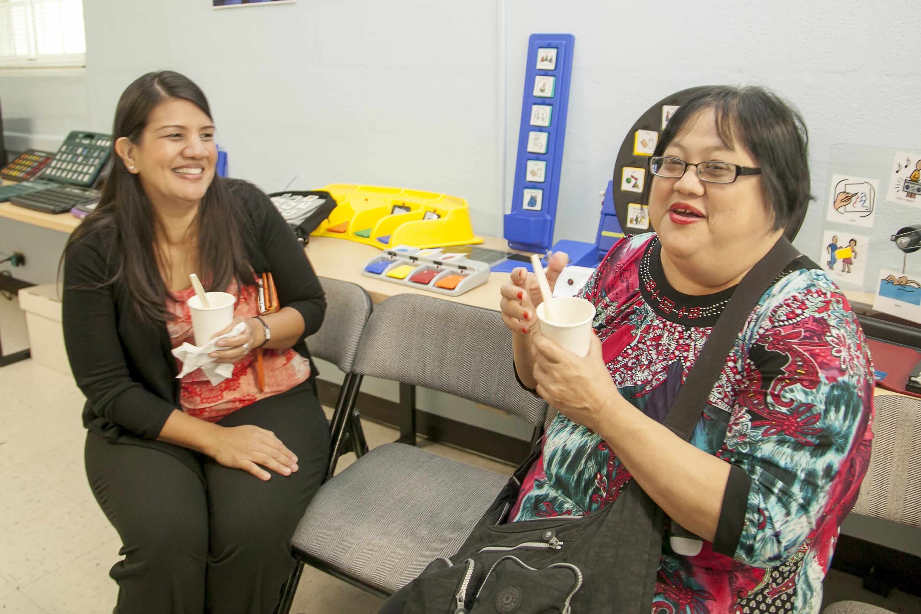 (Left to right) Carol Cabiles from Guam Legal Services, and Lynn Tydingco, SiñA Vice President, enjoy light refreshments after touring the newly renovated AT Demonstration Center.