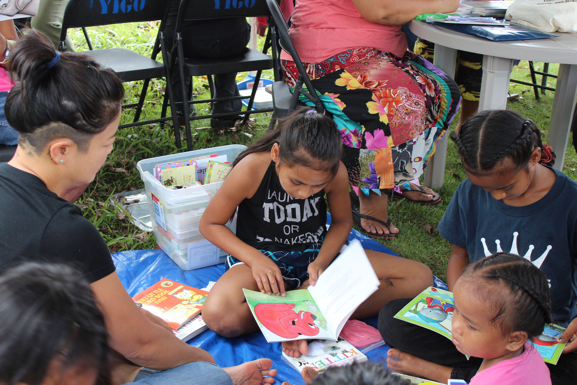 Gajee Parsons, Guam Early Intervention System (GEIS) Social Worker (left),listens to stories read by children during the Power of Play held at Gill Baza, Yigo on June 16.