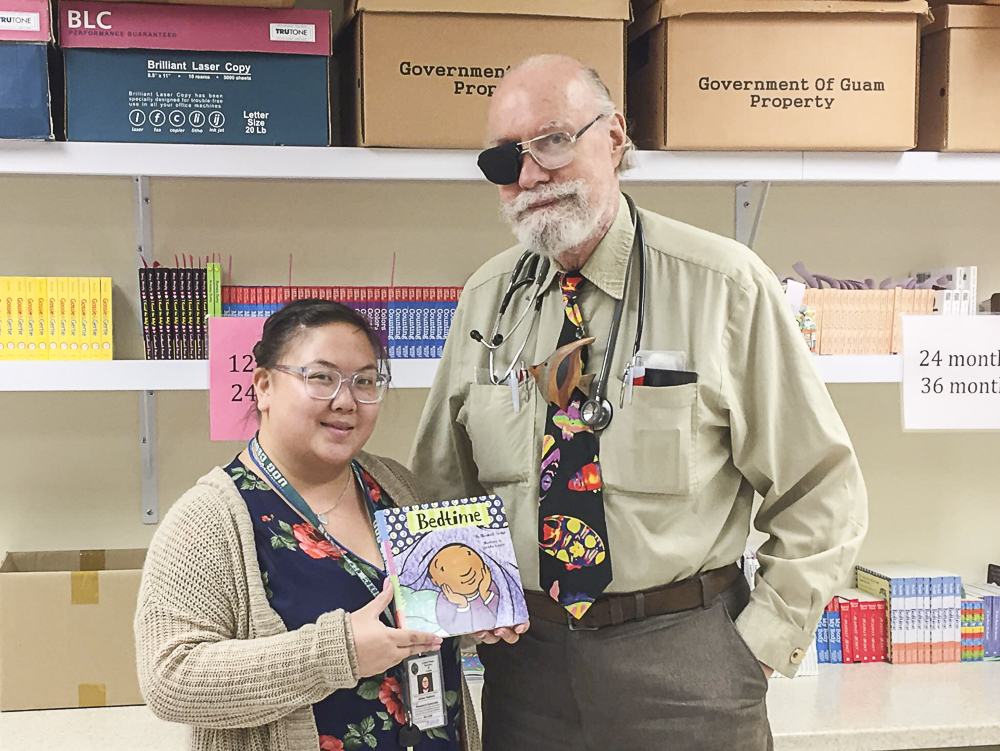 On November 9, Jenika Ballesta (left) and Coleen Dela Cruz (not pictured), Guam CEDDERS, presented books to Dr. Weare, M.D. (right) at the Southern Region Community Health Center as part of the Reach Out and Read Program. 